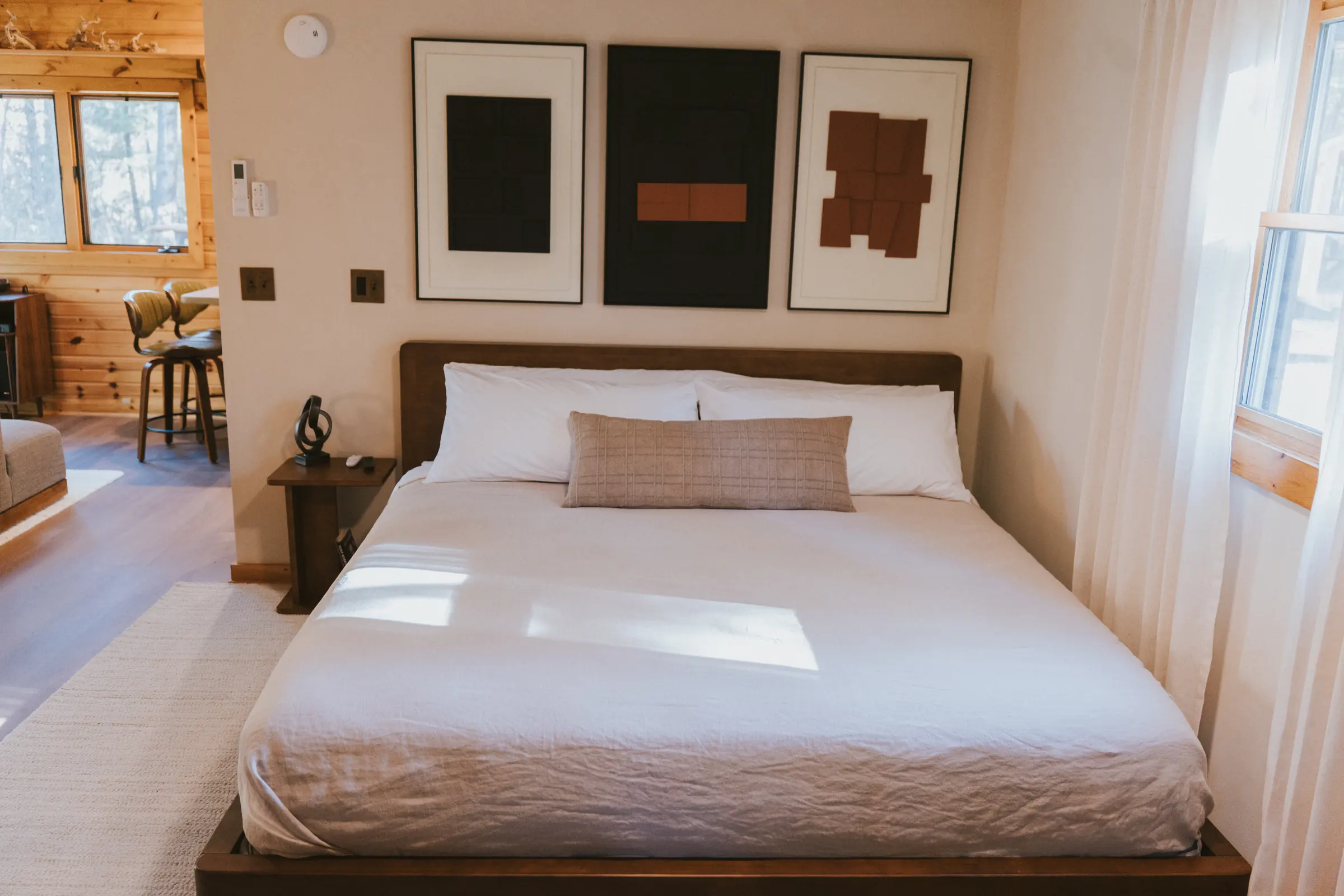 King bed with linen bedding and abstract art