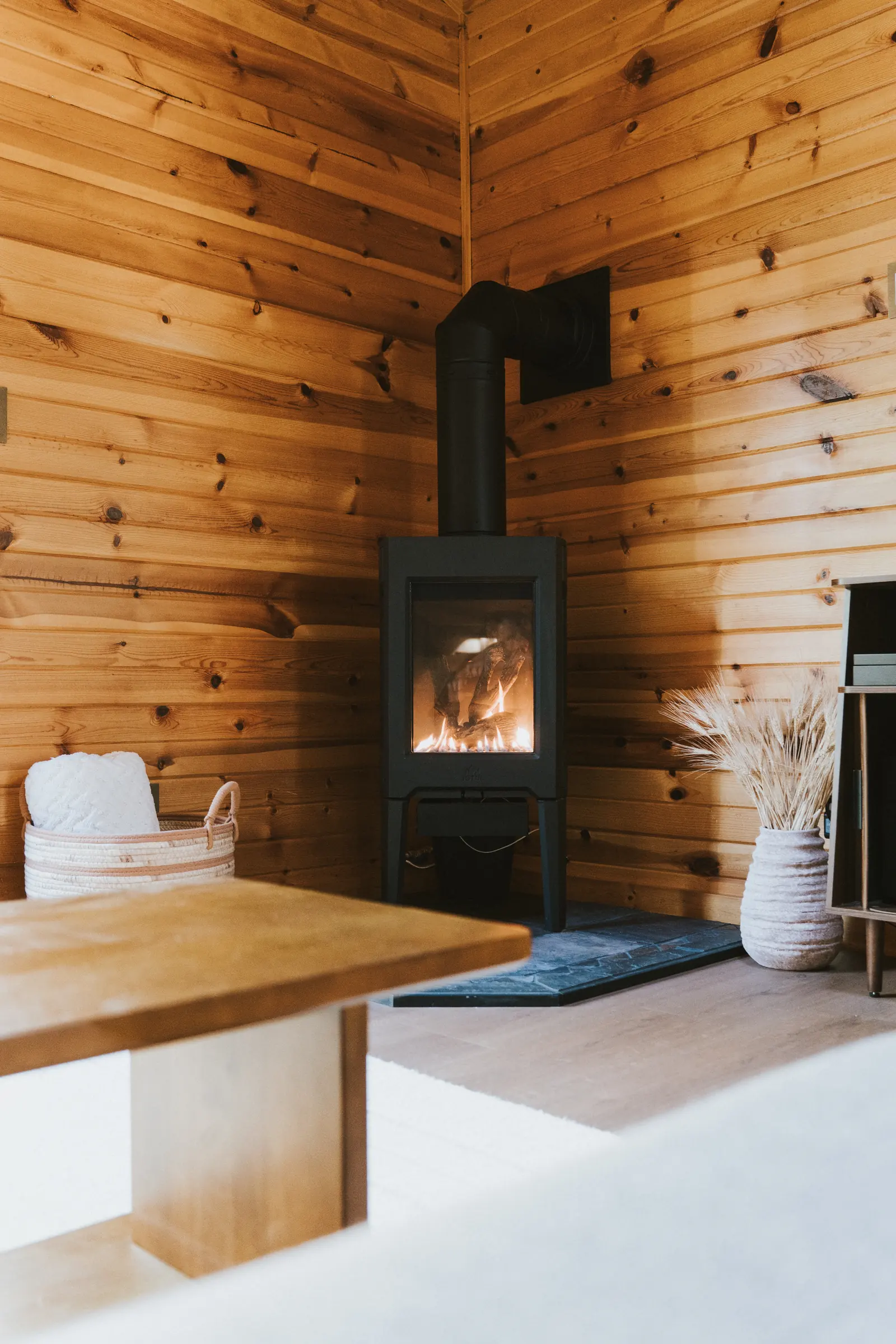 Fire burning in the wood stove in a pine corner
