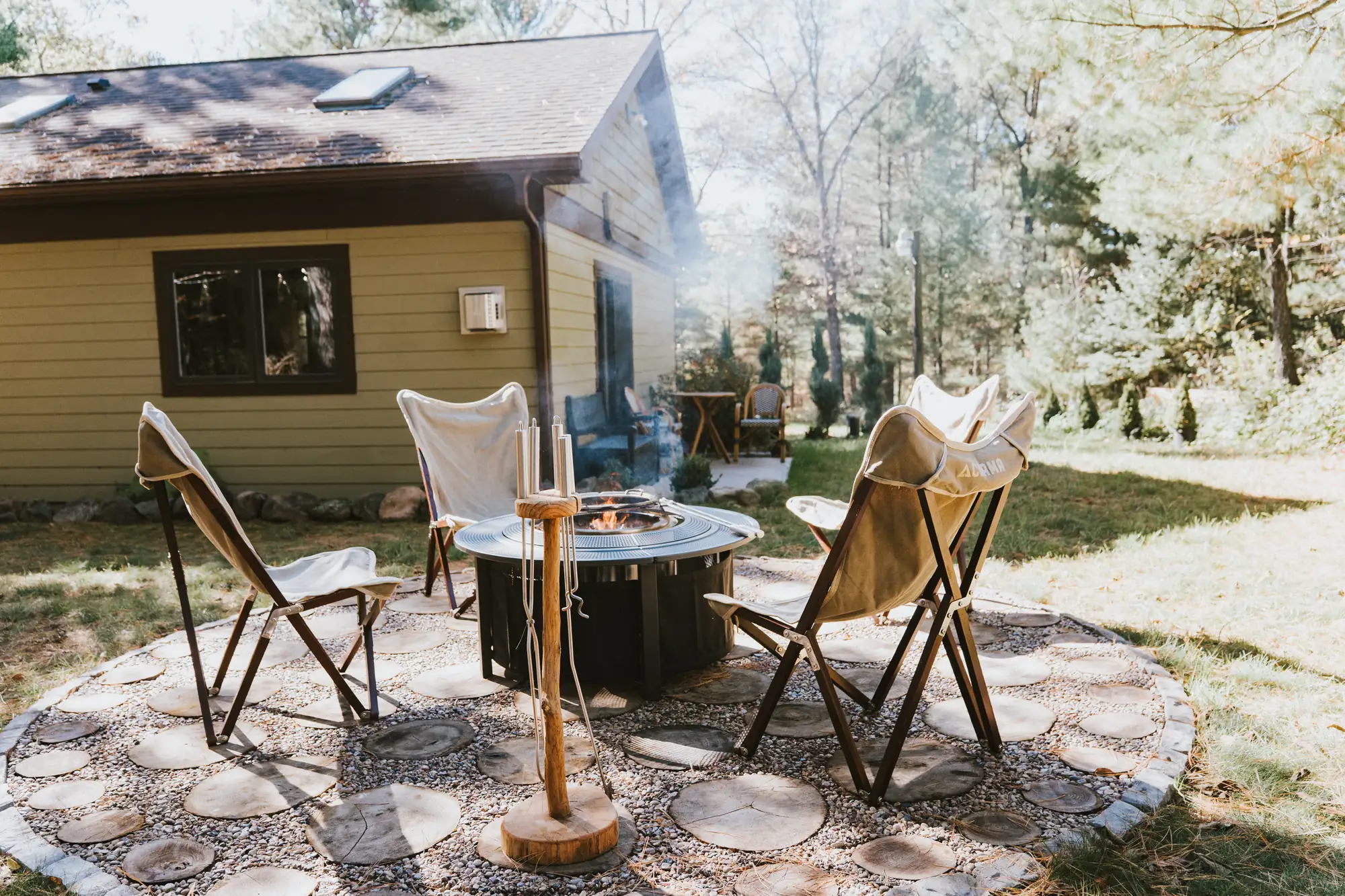 Folding chairs around the fire pit beside the house