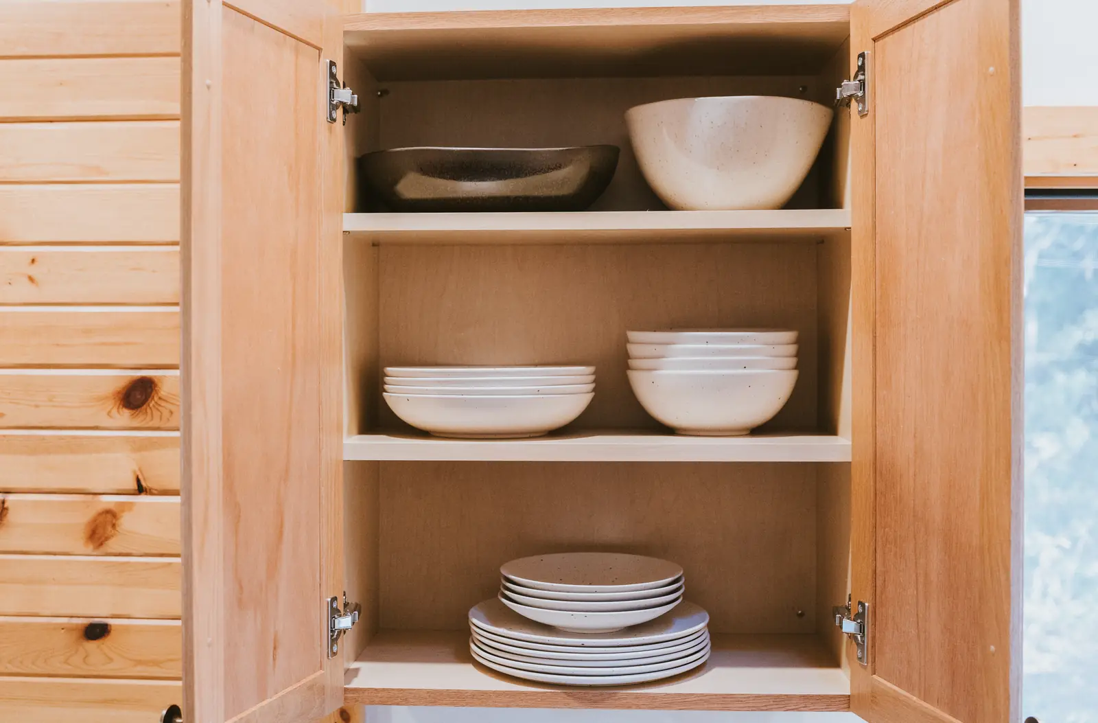 Stoneware bowls and plates in a pine cupboard